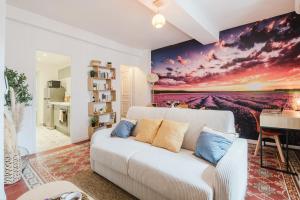 a living room with a white couch and a painting at Lavande Évasion in Avignon