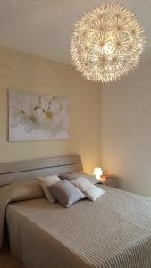 a bedroom with a bed with a large chandelier at Casa Sofia in Caltabellotta