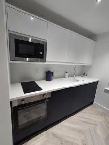 a kitchen with a sink and a microwave at Lanark Apartment in Fort William