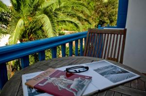 un libro e occhiali seduti su un tavolo sul balcone di Matina Hotel a Mykonos Città