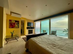 a bedroom with a large bed with a view of the ocean at Oceanfront Villa 4BR 4 BA Real Mediterraneo in Tijuana