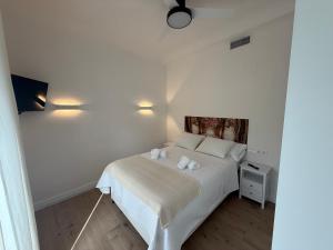 a bedroom with a white bed with two pillows at La Sorpresa in Huétor Vega