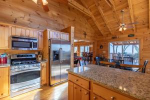 cocina con electrodomésticos de acero inoxidable y comedor en Cardinals View Lodge, en Blowing Rock