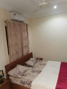 Un dormitorio con una cama y una ventana con publicidad. en Redsea appartement, en Ouagadougou