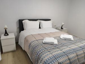 a bedroom with a bed with two towels on it at My Flowers in Árgos Orestikón