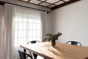 a wooden table with chairs and a vase of flowers on it at La Toldería - Casas de Campo in Trenque Lauquen