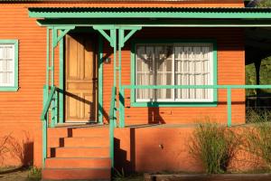 a house with a porch and a door and stairs at La Toldería - Casas de Campo in Trenque Lauquen