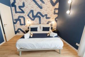 a bedroom with a large bed with a blue wall at xenia apartments & suite in Siracusa +184 photos