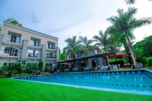 a resort with a swimming pool in front of a building at The Mansion Hotel Jinja in Jinja