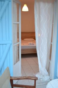um pequeno quarto com uma cama e uma cadeira em Nerina Studios Agios Nikitas em Ayios Nikitas