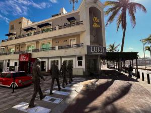 statua trzech mężczyzn idących przed budynkiem w obiekcie Hotel La Siesta Malecón w mieście Mazatlán