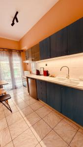 cocina con armarios azules y suelo de baldosa en The Arch Suite, en Tesalónica