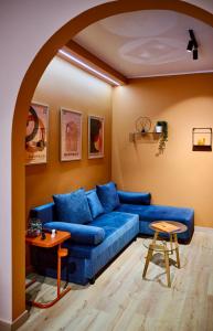 Una sala de estar con un sofá azul y una mesa. en The Arch Suite, en Tesalónica