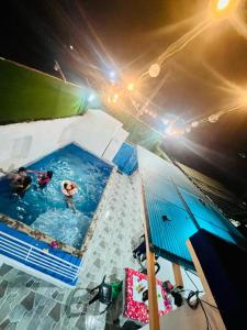 a pool with two people in it with an umbrella at Hadiqah event venue in Mangangpico +2 photos