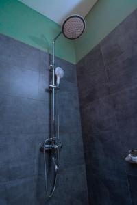 ジンジャにあるThe Mansion Hotel Jinjaの浴室のシャワーヘッド付きシャワー