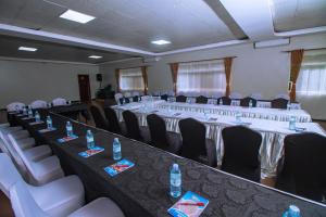 ジンジャにあるThe Mansion Hotel Jinjaの長いテーブルと椅子、そして水のボトルが置かれた会議室 +69枚の写真