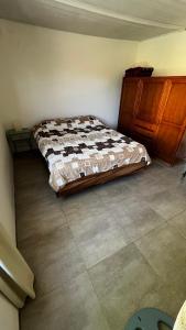 a bedroom with a bed and a wooden cabinet at Casa en playa Quequen in Quequén +10 photos