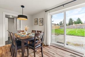 a dining room with a table and chairs and a large window at Cozy North Seattle Rambler with Spacious Yard in Seattle