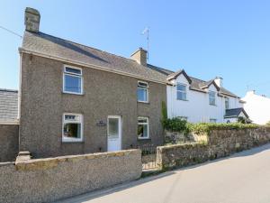 una antigua casa de ladrillo con una pared de piedra en 2 Bryn Hyfryd, en Abersoch