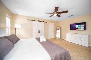 a bedroom with a large bed and a ceiling fan at Private Heated Pool Arcade Games Sleeps 10 Jacksonville Home in Jacksonville +35 photos