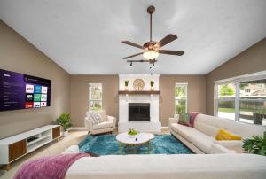a living room with a couch and a ceiling fan at Private Heated Pool Arcade Games Sleeps 10 Jacksonville Home in Jacksonville