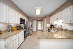 a kitchen with white cabinets and granite counter tops at Private Heated Pool Arcade Games Sleeps 10 Jacksonville Home in Jacksonville