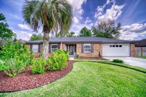 a palm tree in front of a house at Private Heated Pool Arcade Games Sleeps 10 Jacksonville Home in Jacksonville