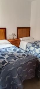 a bedroom with two beds and a dresser and a bed sidx sidx sidx sidx at Casa Doris in Los Alcázares