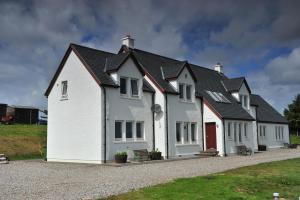 uma casa branca com um telhado preto em Beinn Edra House B&B em Staffin