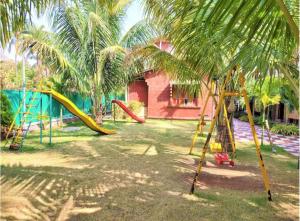 a playground with slides and palm trees in a yard at Kashid Boutique Resort in Sarne