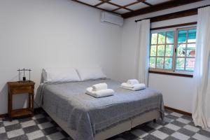 a bedroom with a bed with two towels on it at La Toldería - Casas de Campo in Trenque Lauquen