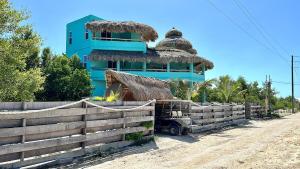 a blue building with a fence in front of it at Shipwreck Cove in Caye Caulker