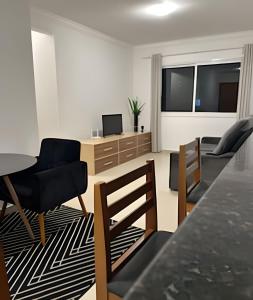 a living room with a table and chairs and a dining room at Ap Central - Vista deslumbrante in Ponta Grossa +8 photos