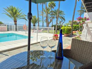 two wine glasses on a table next to a pool at 8i Ocean Front Playa 4 in San Bartolomé