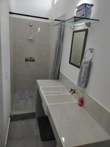 Un baño blanco con lavabo y espejo. en Casa los Sauces, en Tepic 18 fotos más