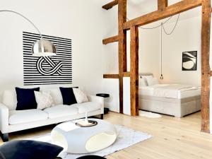 a living room with a white couch and a table at Neu MAKERS and ROOMS APARTMENTS Rosental am Schlosspark Detmold in Detmold