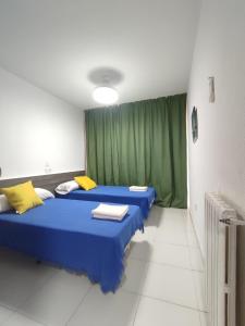 two beds in a room with a green curtain at Lux Benidorm in Benidorm +81 photos