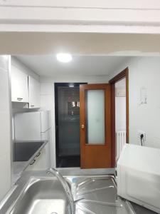 a kitchen with a sink and a brown door at Lux Benidorm in Benidorm