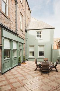 a patio with a table and chairs next to a building at Sidey Court in Berwick-Upon-Tweed