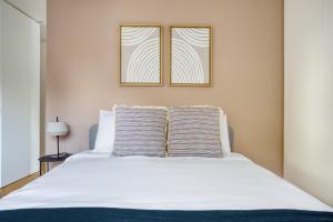 a bedroom with a white bed with two windows at Belo Quarto com WC Privativo in Lisbon