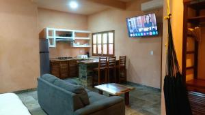 a living room with a couch and a kitchen at Casa XhunaXhia in Zipolite