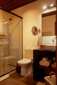 a bathroom with a toilet and a shower and a sink at Pausa Trancoso in Trancoso +29 photos