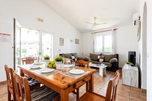 a dining room and living room with a table and chairs at Villa Miguel in Cala en Bosc +3 photos