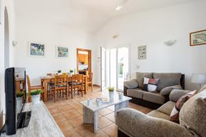 a living room with a couch and a table at Villa Miguel in Cala en Bosc