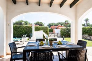 an outdoor dining area with a table and chairs at Villa Miguel in Cala en Bosc