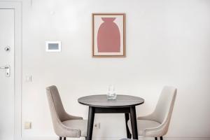 a black table with chairs and a vase on the wall at Belo Quarto com WC Privativo in Lisbon