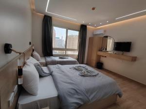 una camera d'albergo con due letti e una finestra di Landmark Hostel Cairo a Il Cairo