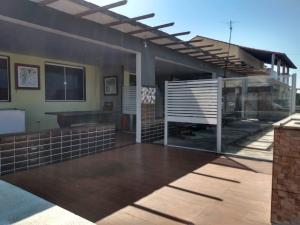 a house with a large patio with a deck at Pousada Perola Beach in Maricá