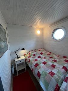 a small bedroom with a bed and a lamp on a table at Stuga Björkdalen in Växjö