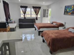 Una sala de estar con dos camas y un sofá en Casa los Sauces, en Tepic